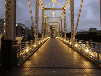 Illuminated bridge against sky in city