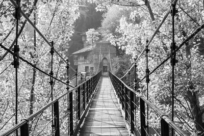 Footbridge amidst trees against clear sky