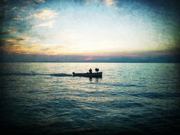 Boat sailing in sea at sunset