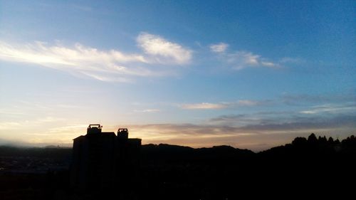 Silhouette of building against sunset sky