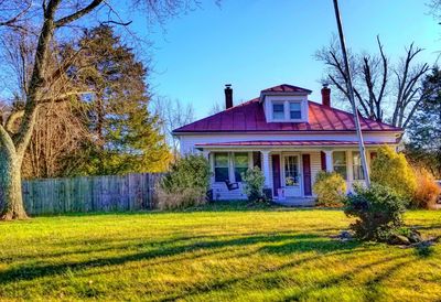 House on field against clear blue sky