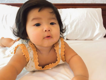 Close-up of cute girl relaxing on bed at home