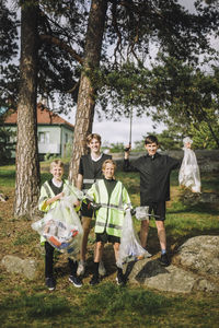 Portrait of smiling boys standing with plastic bags