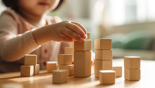 Midsection of girl playing with toy blocks