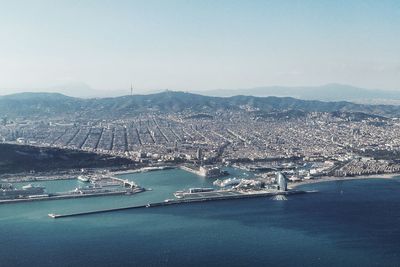 High angle view of city by sea against sky