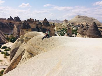 Panoramic view of man riding rocks on shore against sky