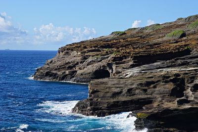 Rock formations by sea against sky