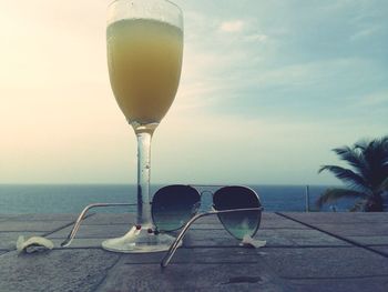 Close-up of sunglasses on beach against sky during sunset