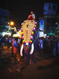 People walking on illuminated street at night