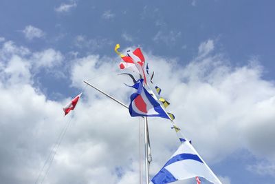Low angle view of flags against sky