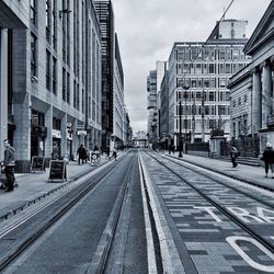 View of city street against cloudy sky