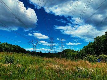 Electricity pylon on field against sky