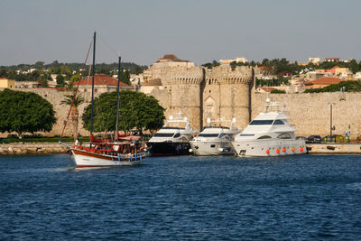 Boats moored on sea against castle