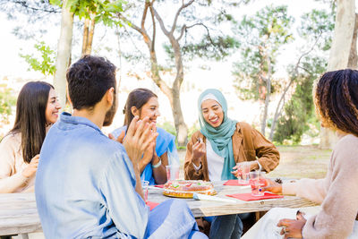 Side view of friends having food at home