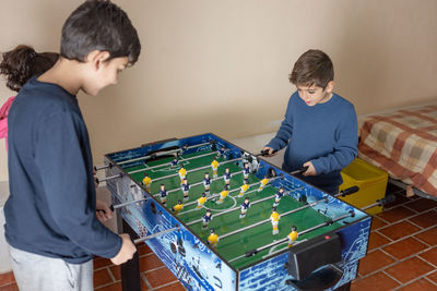 Side view of kid playing table soccer