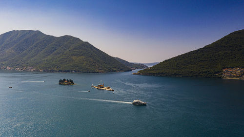 Scenic view of sea and mountains against clear sky