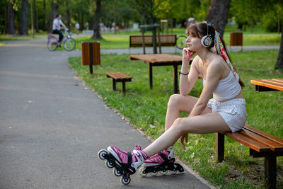 Side view of woman sitting on road