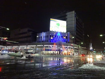 Illuminated city street during rainy season at night