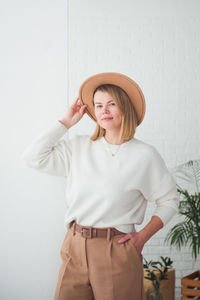 Trendy woman wearing brown hat smiling and looking at camera