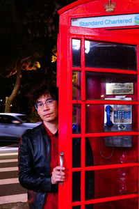 Portrait of young man using phone at night