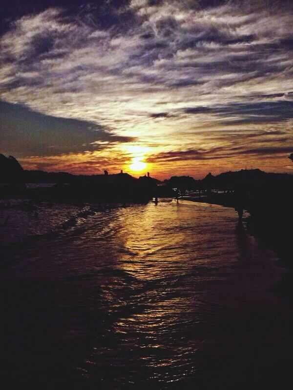 sunset, water, sky, scenics, tranquil scene, silhouette, beauty in nature, tranquility, cloud - sky, orange color, waterfront, reflection, nature, idyllic, cloud, sun, sea, rippled, cloudy, dramatic sky