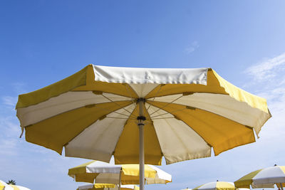 Low angle view of parasols against sky