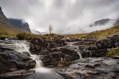 Scenic view of waterfall against sky