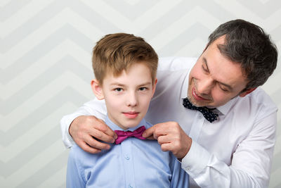 Close-up of smiling father and son at home