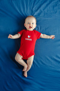 High angle view of cute baby girl on bed