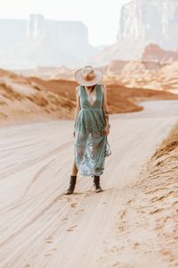 Rear view of woman walking in desert