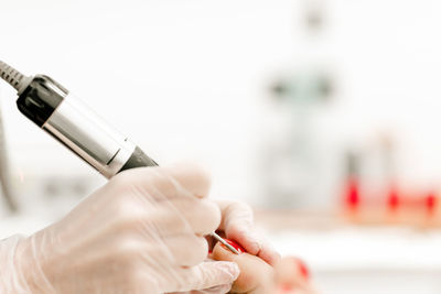 Cropped hand of woman holding thermometer