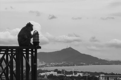 People sitting on mountain against sky