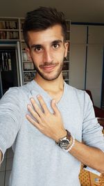 Portrait of young man standing at home