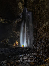 Blurred motion of waterfall against rocks in sea