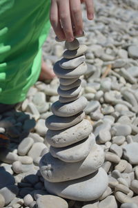 Close-up of person stacking pebbles