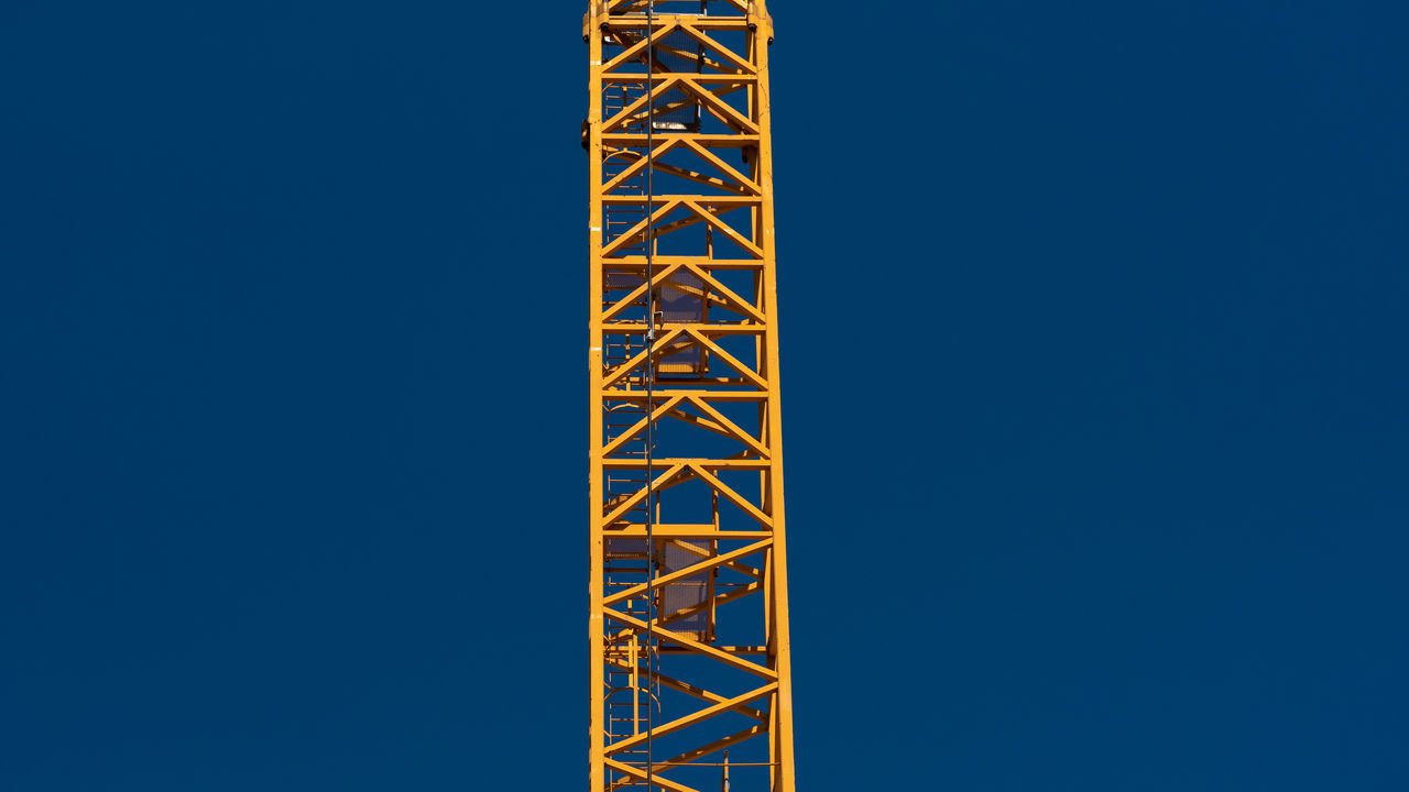 LOW ANGLE VIEW OF COMMUNICATIONS TOWER AGAINST BLUE SKY