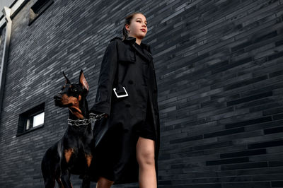 Teen girl walking down the street with her doberman. great view.  security and confidence concept