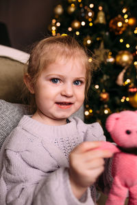 Portrait of cute girl with christmas tree at home
