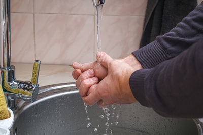 Cropped hand of man washing hands