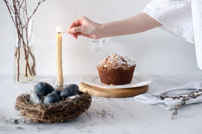 Cropped hand of person preparing food on table