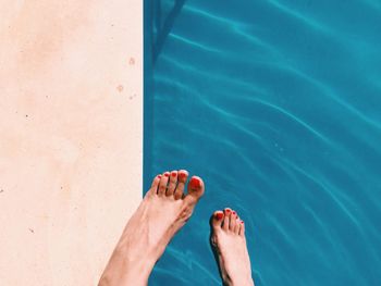 Low section of person standing in water