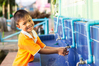 Side view of boy washing hands at park