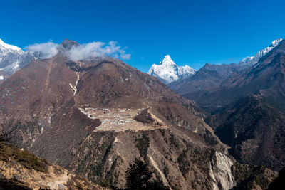 Scenic view of snowcapped mountains against blue sky