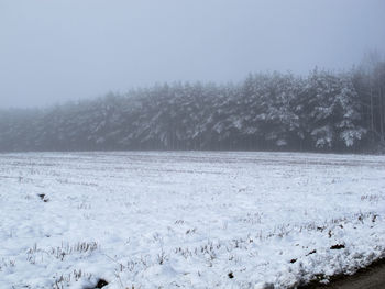 Scenic view of snow covered land against sky