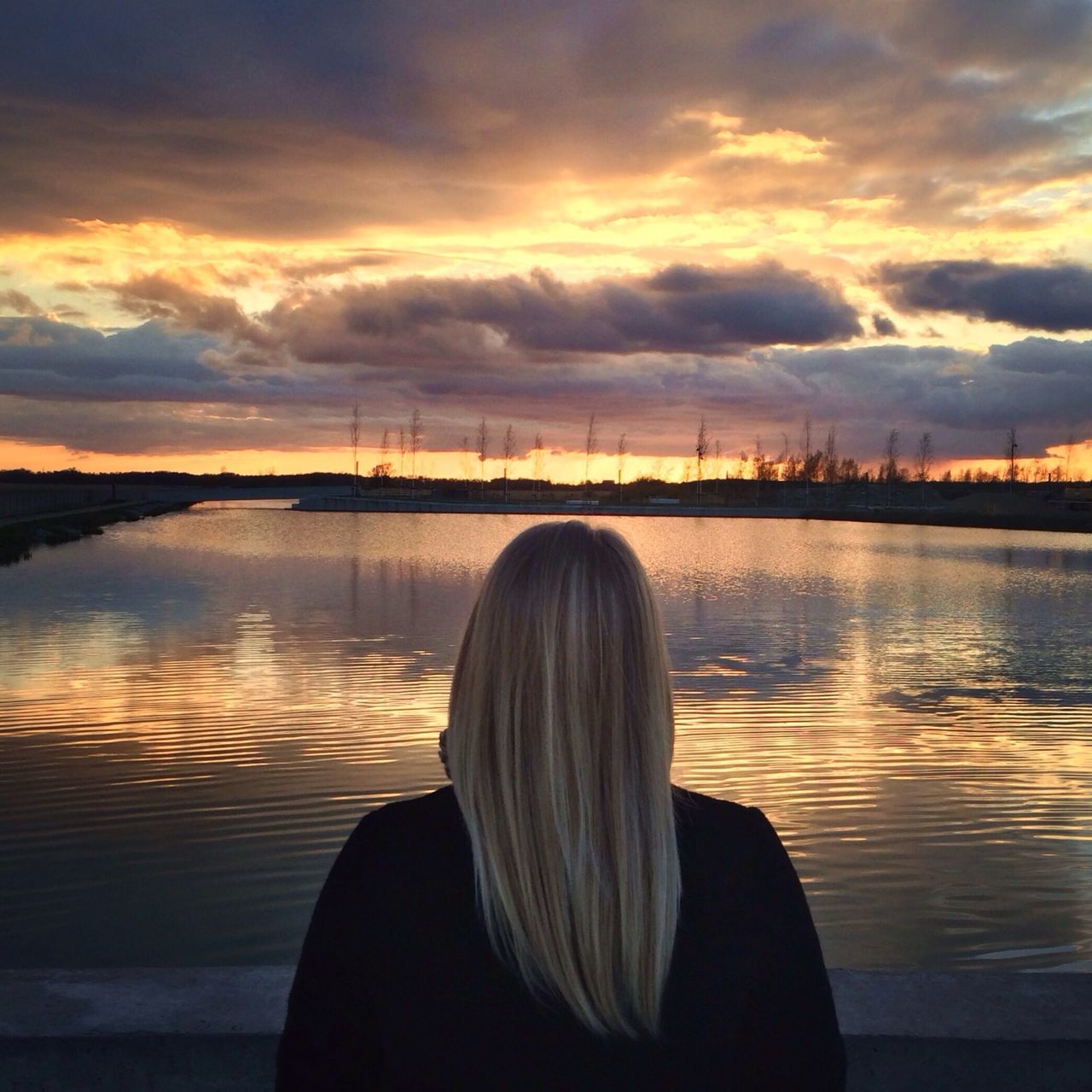 sunset, water, sky, rear view, cloud - sky, lake, silhouette, lifestyles, river, orange color, leisure activity, person, standing, cloud, waist up, reflection, tranquil scene, tranquility