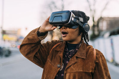 Young woman with mouth open using virtual reality headset