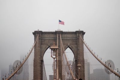 Low angle view of suspension bridge against sky