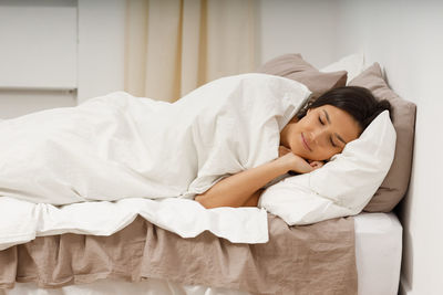 Young woman sleeping on bed at home