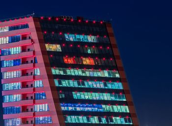 Low angle view of illuminated building against blue sky