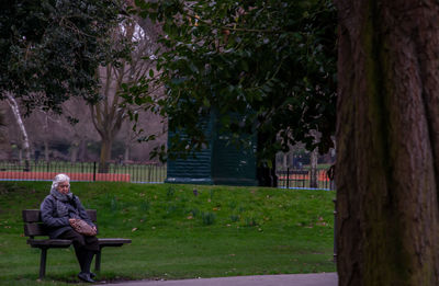 Woman sitting on bench in park